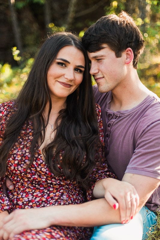 Girl looking at camera while fiancé admires her. Brandon and Shelby linger over each other for a kiss. Photo by Arkansas Wedding Collection.