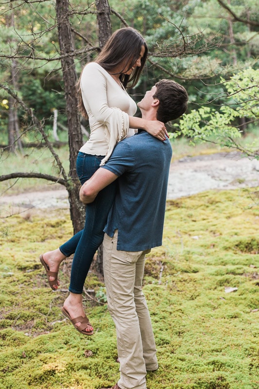 Man lifting his fiancé up on a trail at Petit Jean State Park. Photo by Arkansas Wedding Collection.