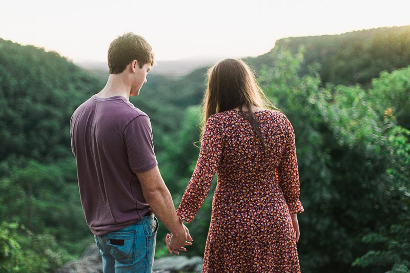 Couple holding hands and looking over the overlook at Petit Jean State Park. Photo by Arkansas Wedding Collection.