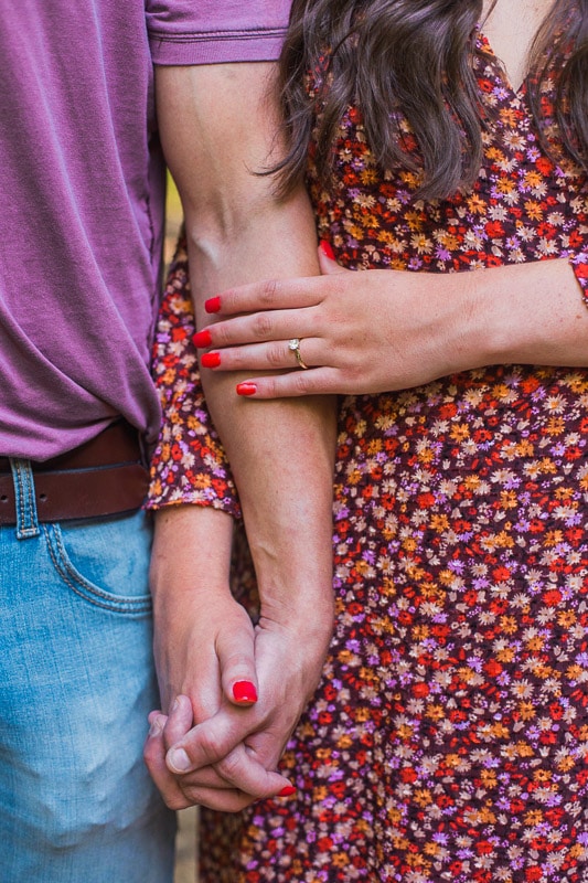 Couple holding hands and showing off engagement ring. Photo by Arkansas Wedding Collection.