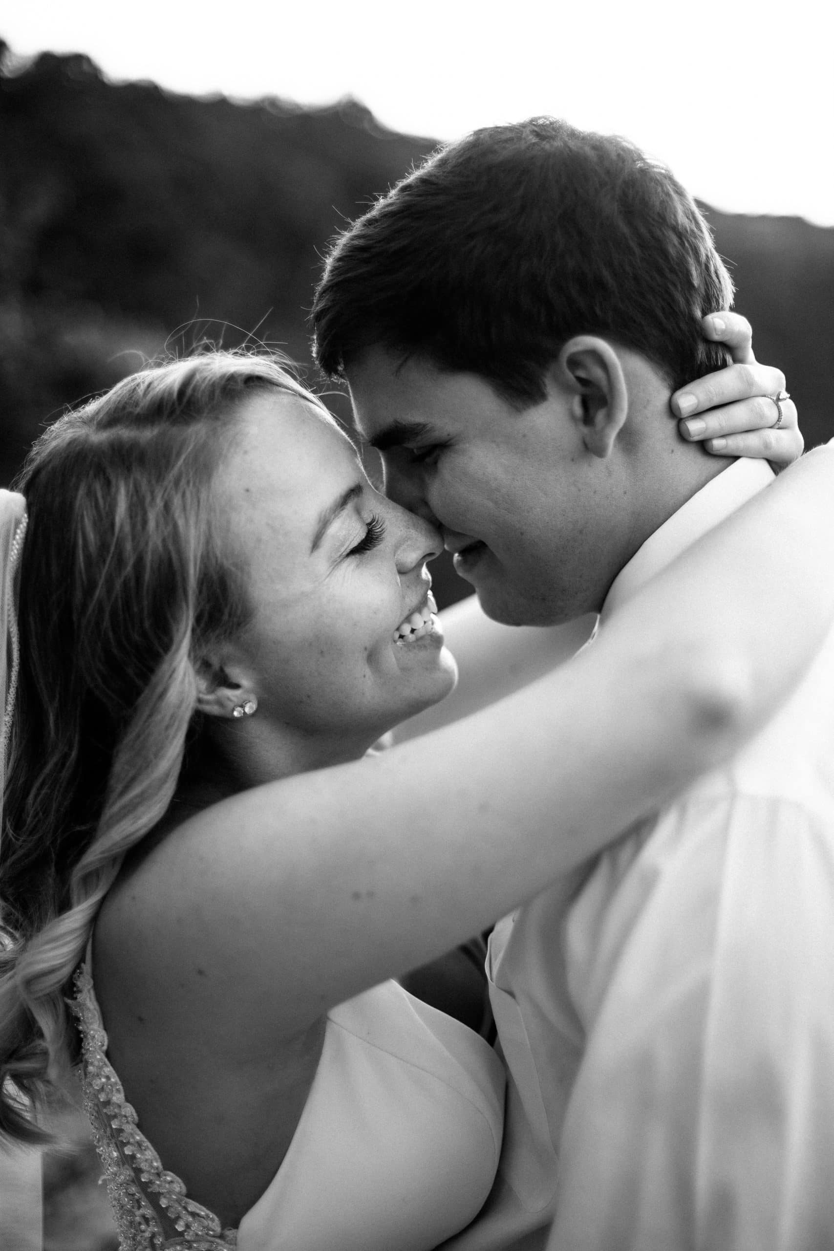 bride and groom holding each other close in black and white