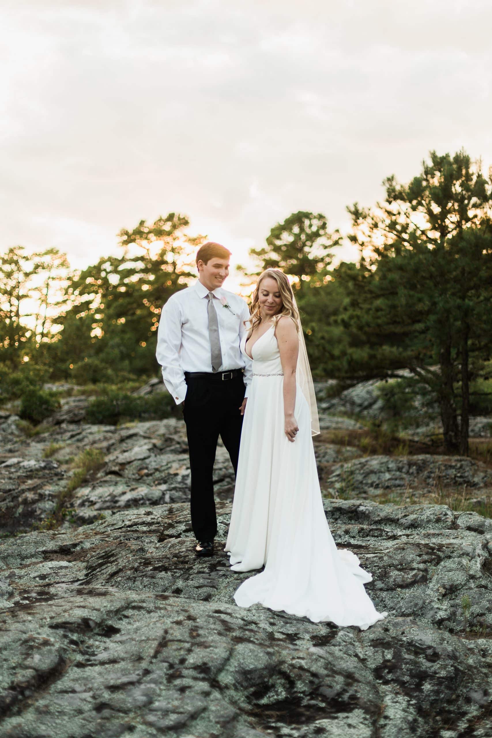 bride and groom standing on a rocky path