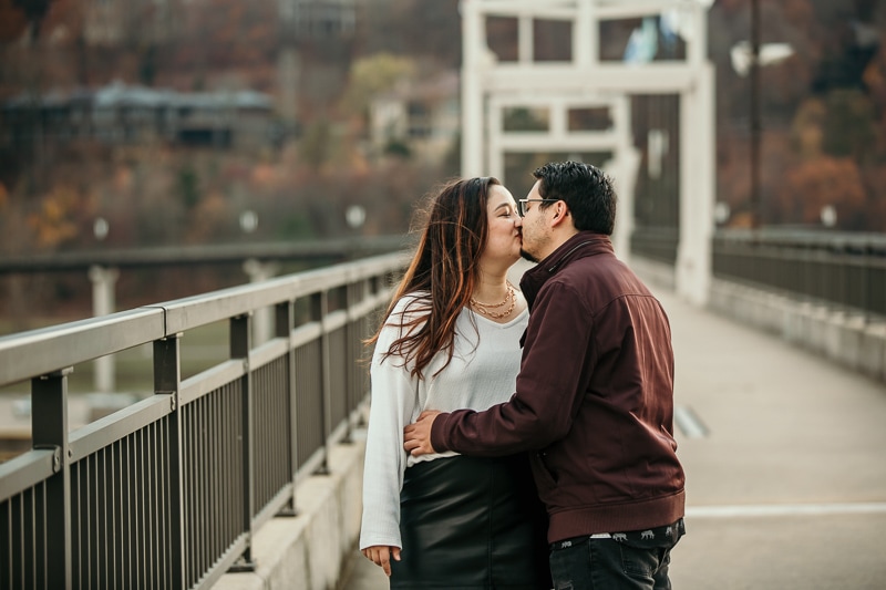 couple kissing on bridge