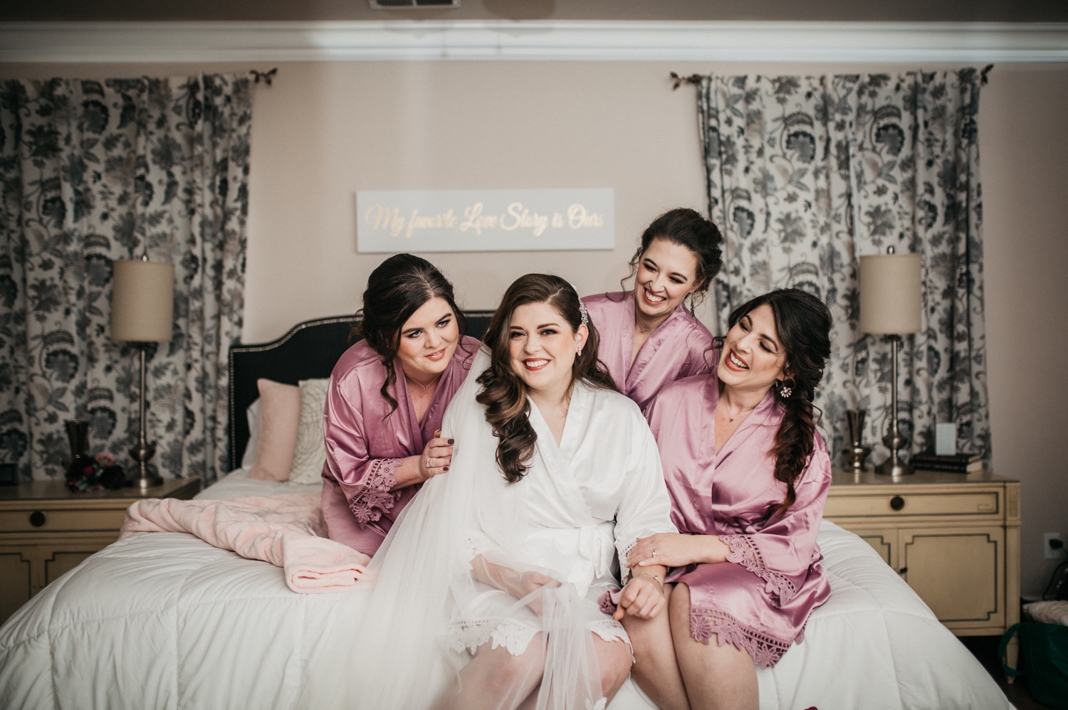 bride-sitting-on-bed-with-bridesmaids